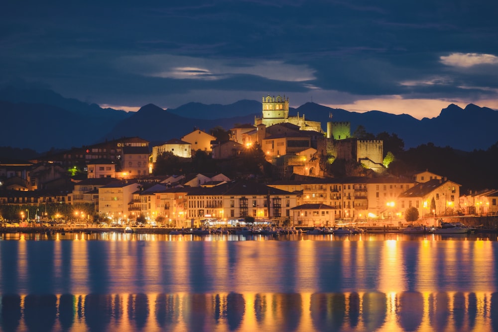 a city lit up at night by the water