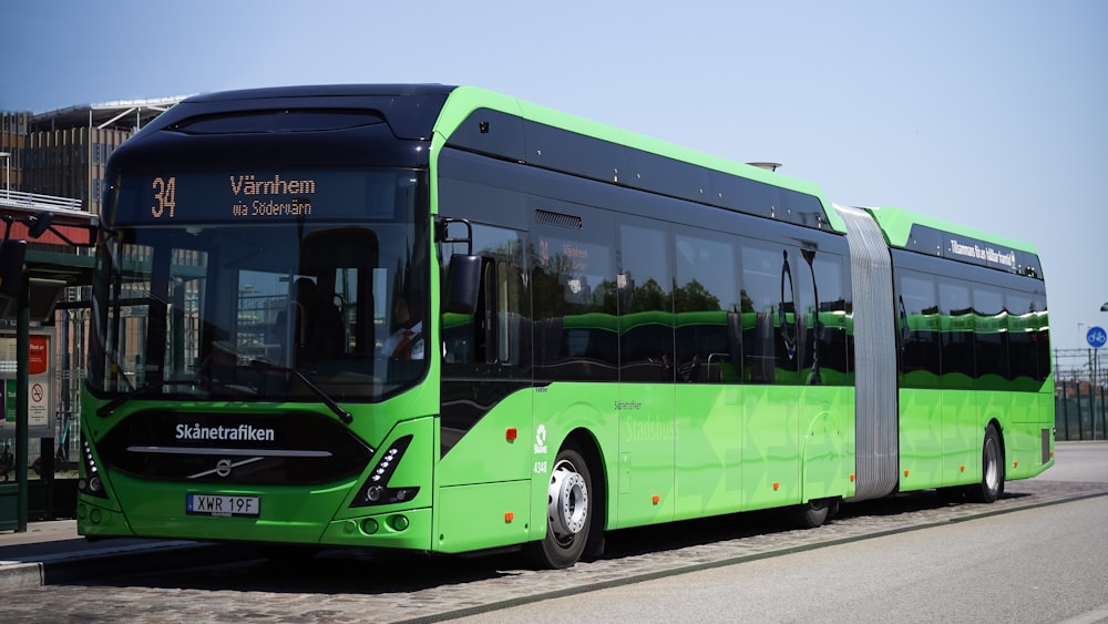 a green bus parked on the side of the road