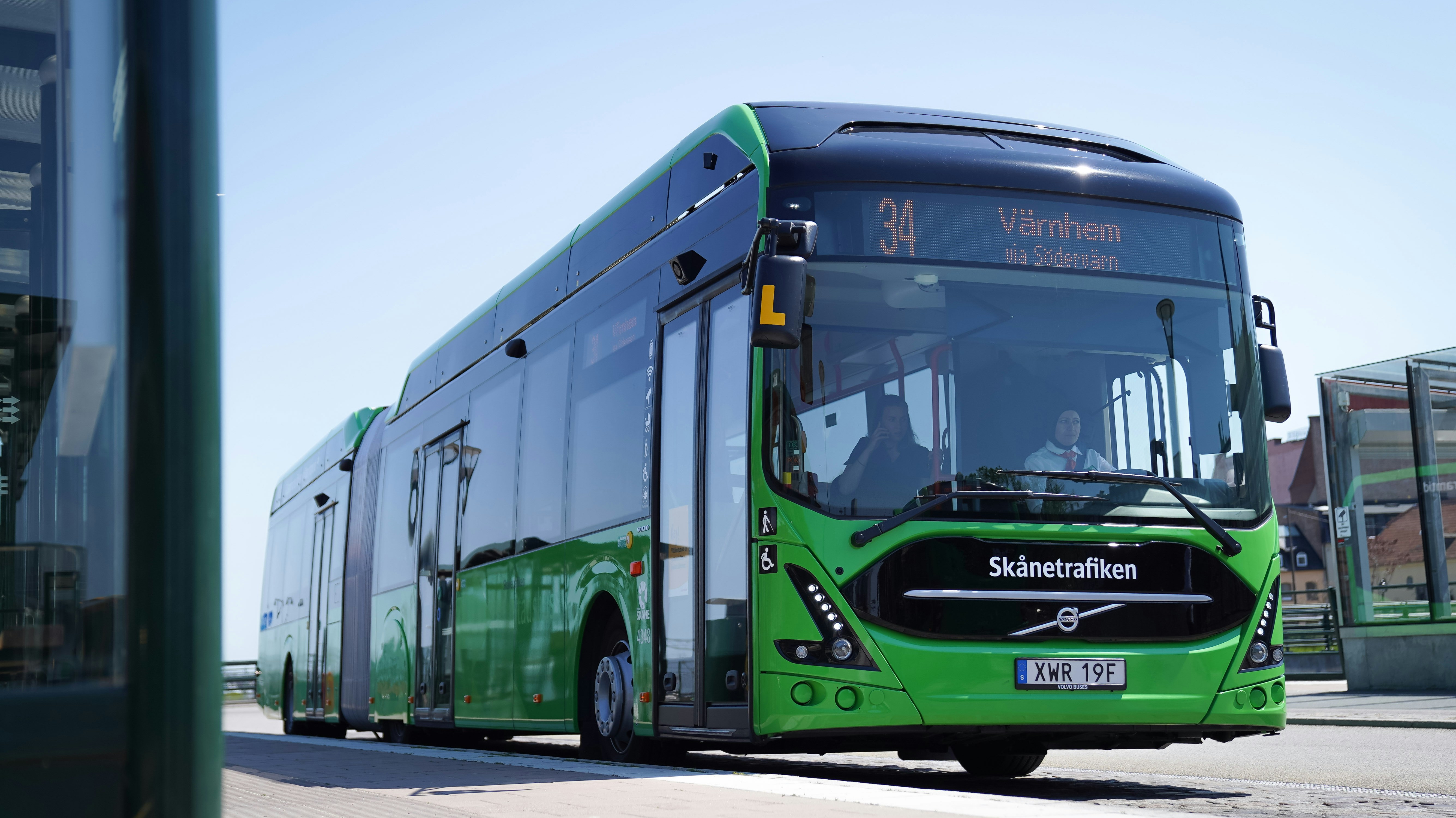 a green bus parked on the side of the road