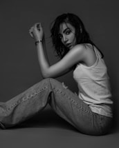 a woman is sitting on the floor posing for a picture