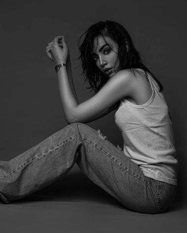 a woman is sitting on the floor posing for a picture