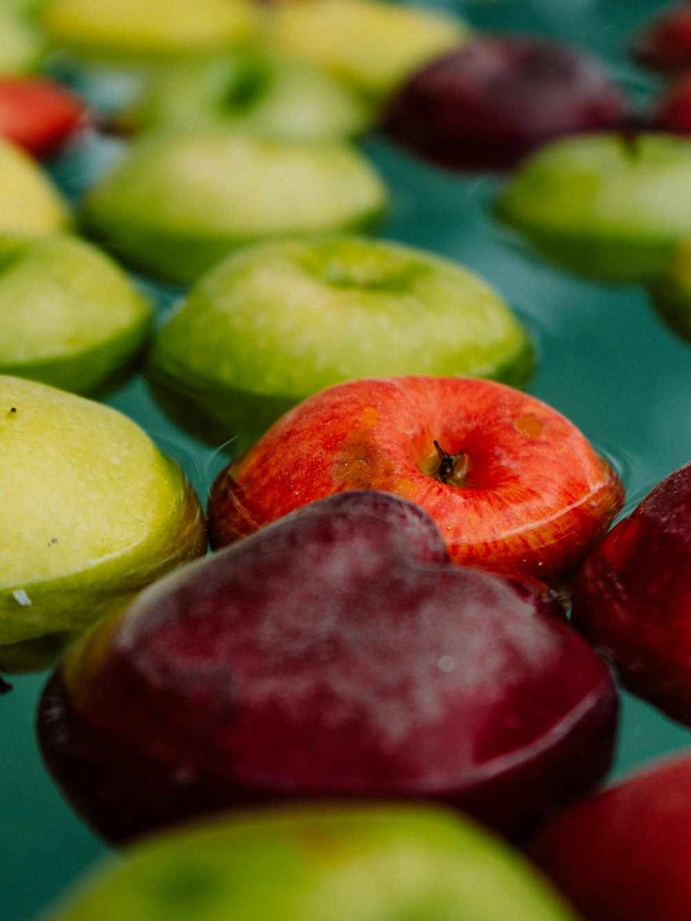 a close up of a bunch of apples in a pool of water