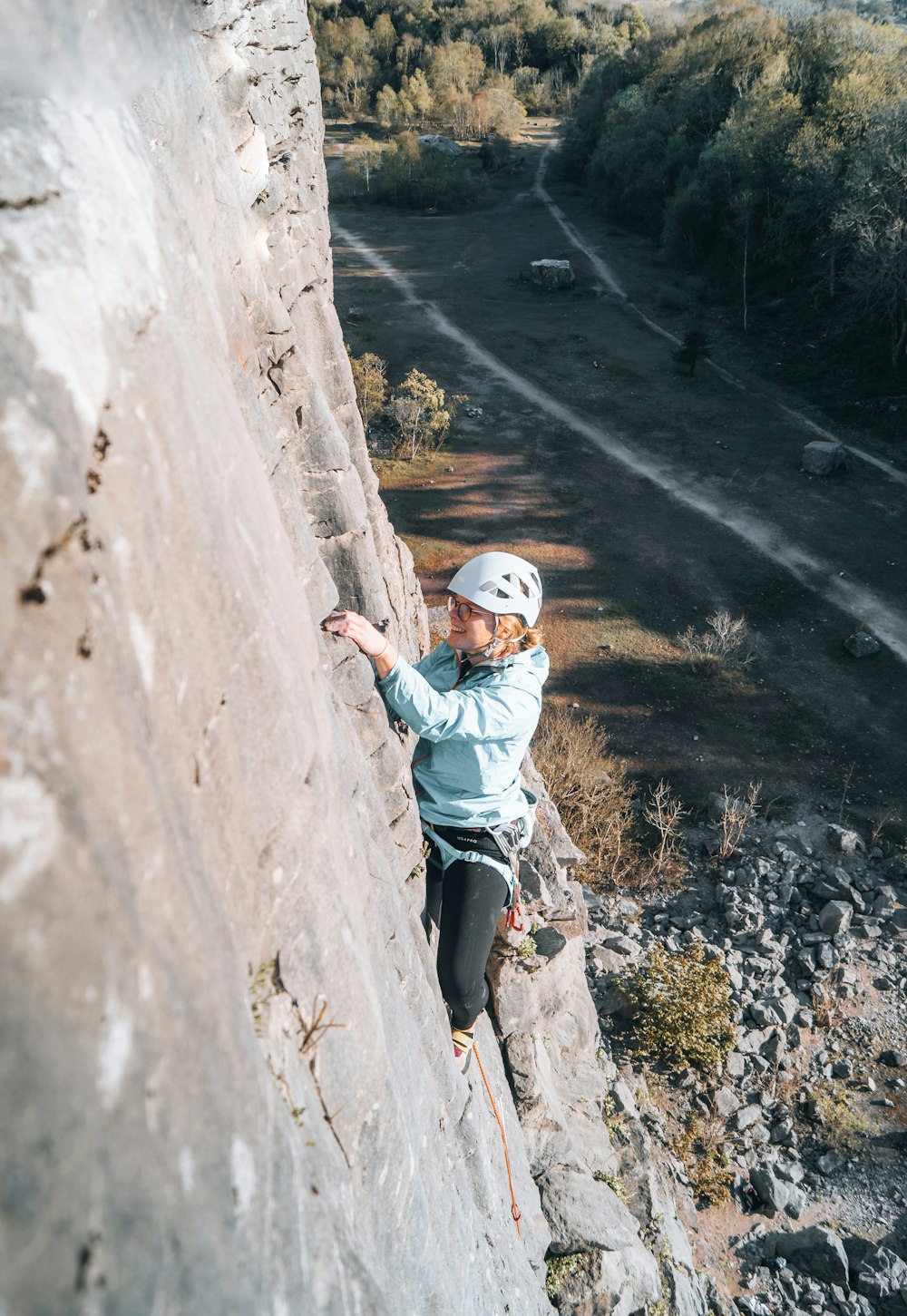 a woman climbing up the side of a mountain