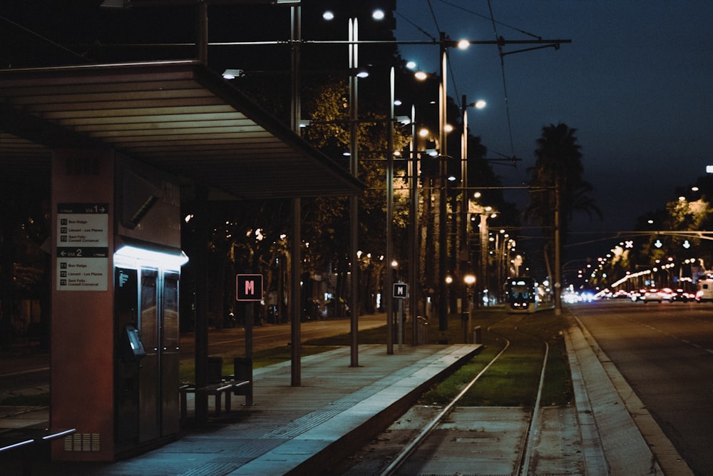 a train station at night with a train on the tracks