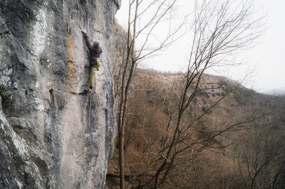 a man climbing up the side of a cliff