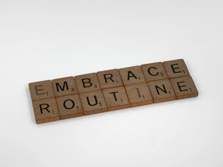 a scrabbled word that says embrace routine on a white background
