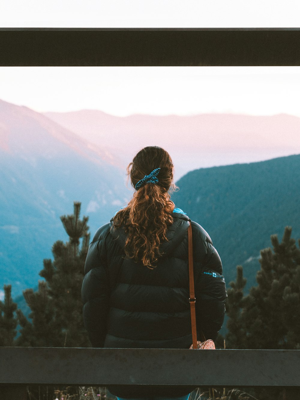 a woman standing on top of a wooden bench