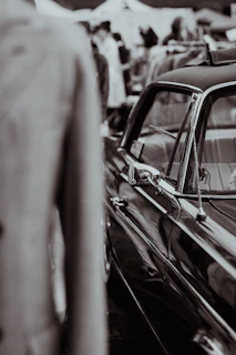 a black and white photo of a man in a car