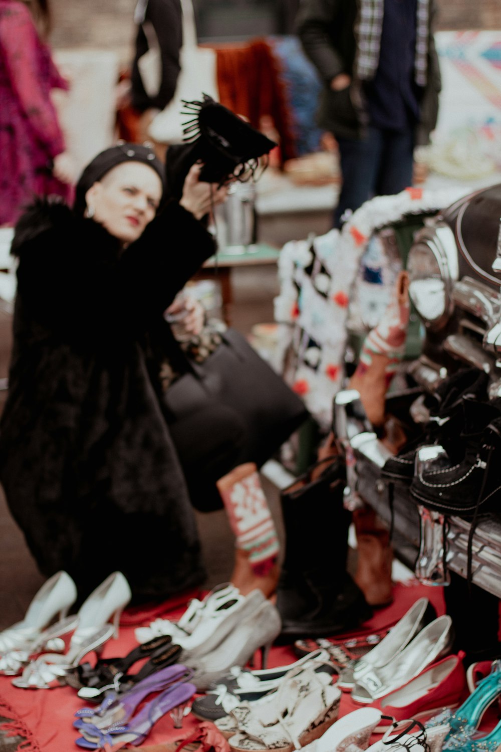 a woman in a black fur coat looking at shoes