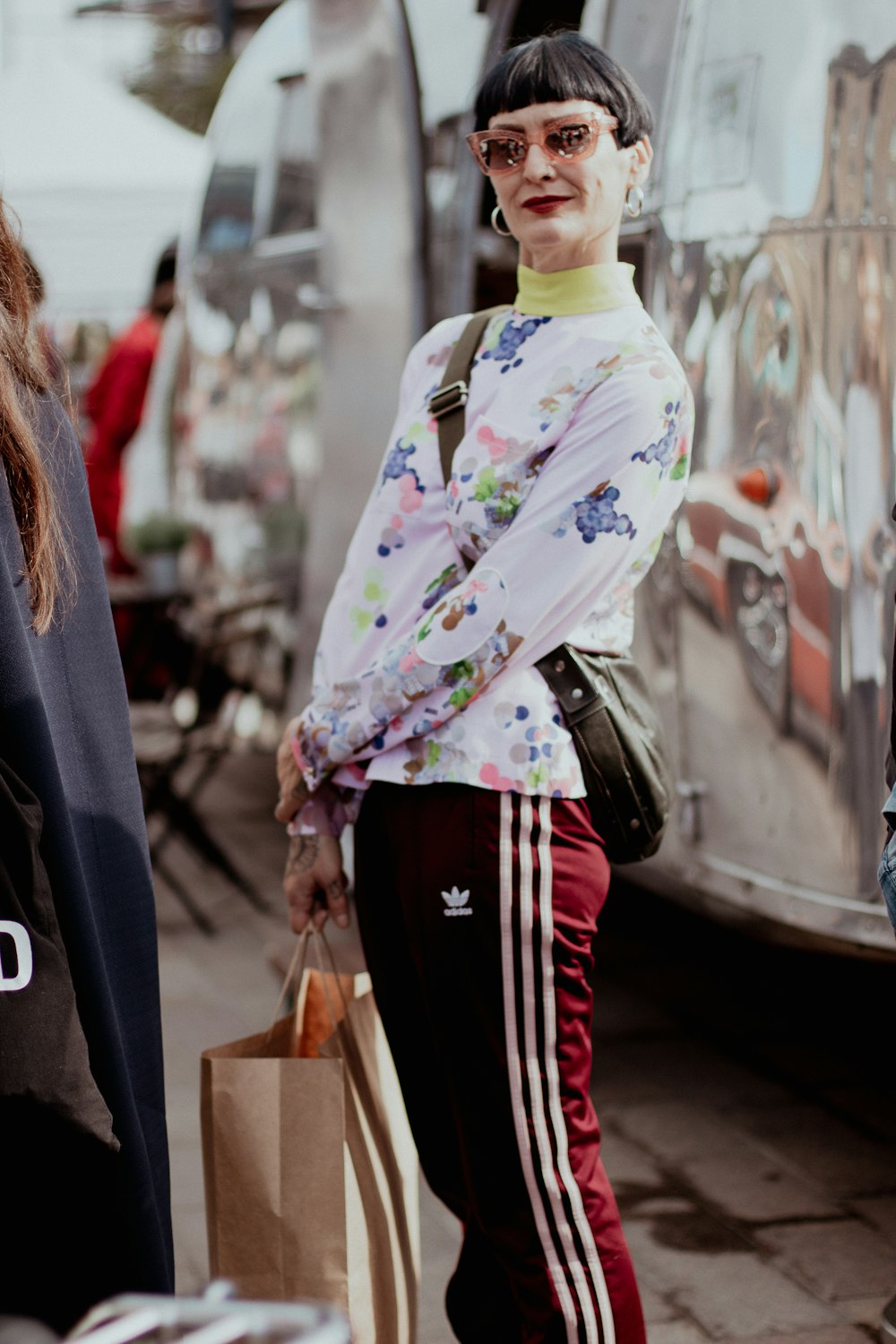 a woman is standing on the street with shopping bags