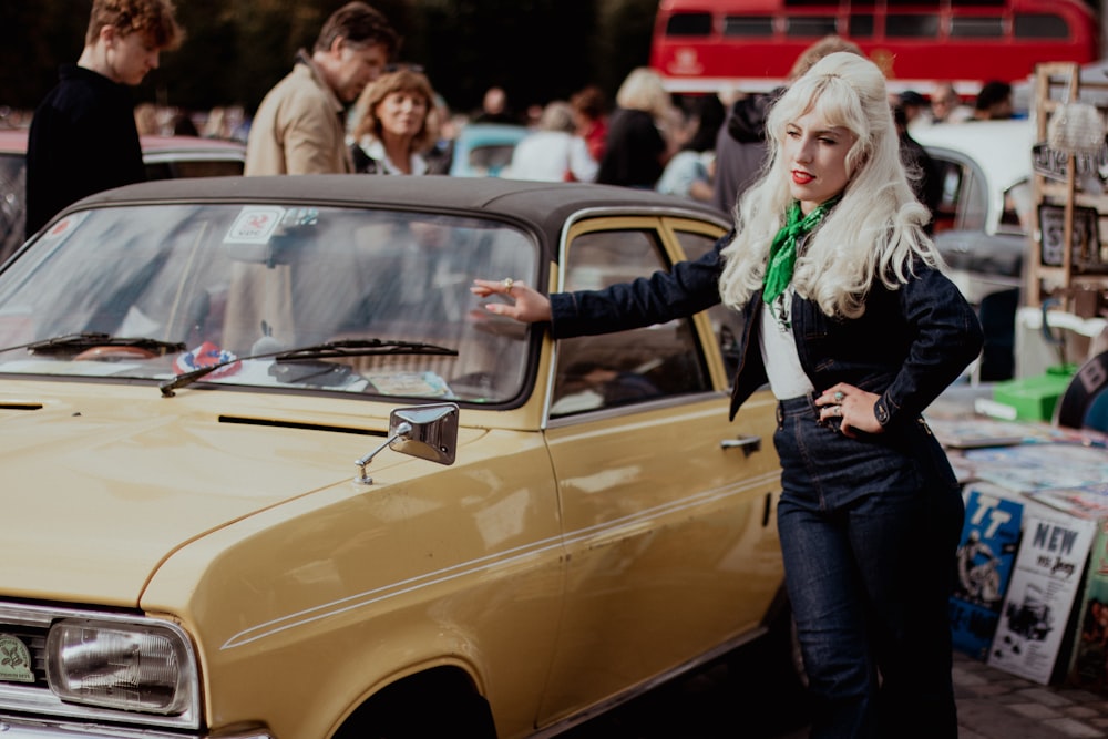 a woman standing next to a car in a parking lot