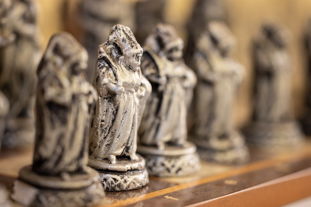 a group of statues sitting on top of a wooden shelf