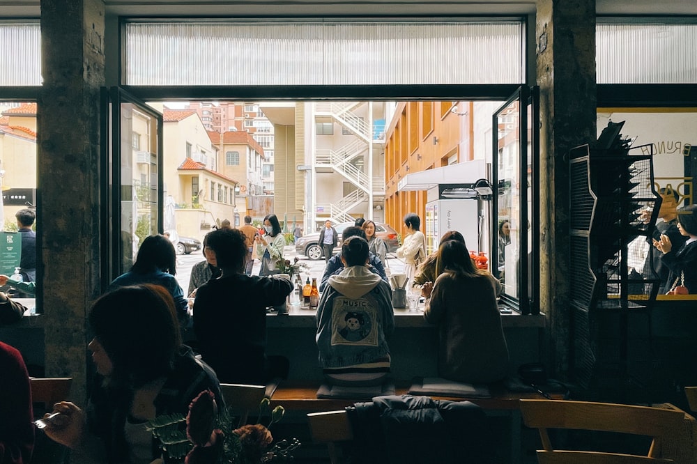 a group of people sitting at a table in front of a window