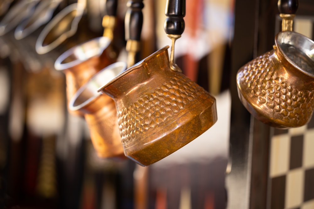 a number of pots and pans hanging from a rack