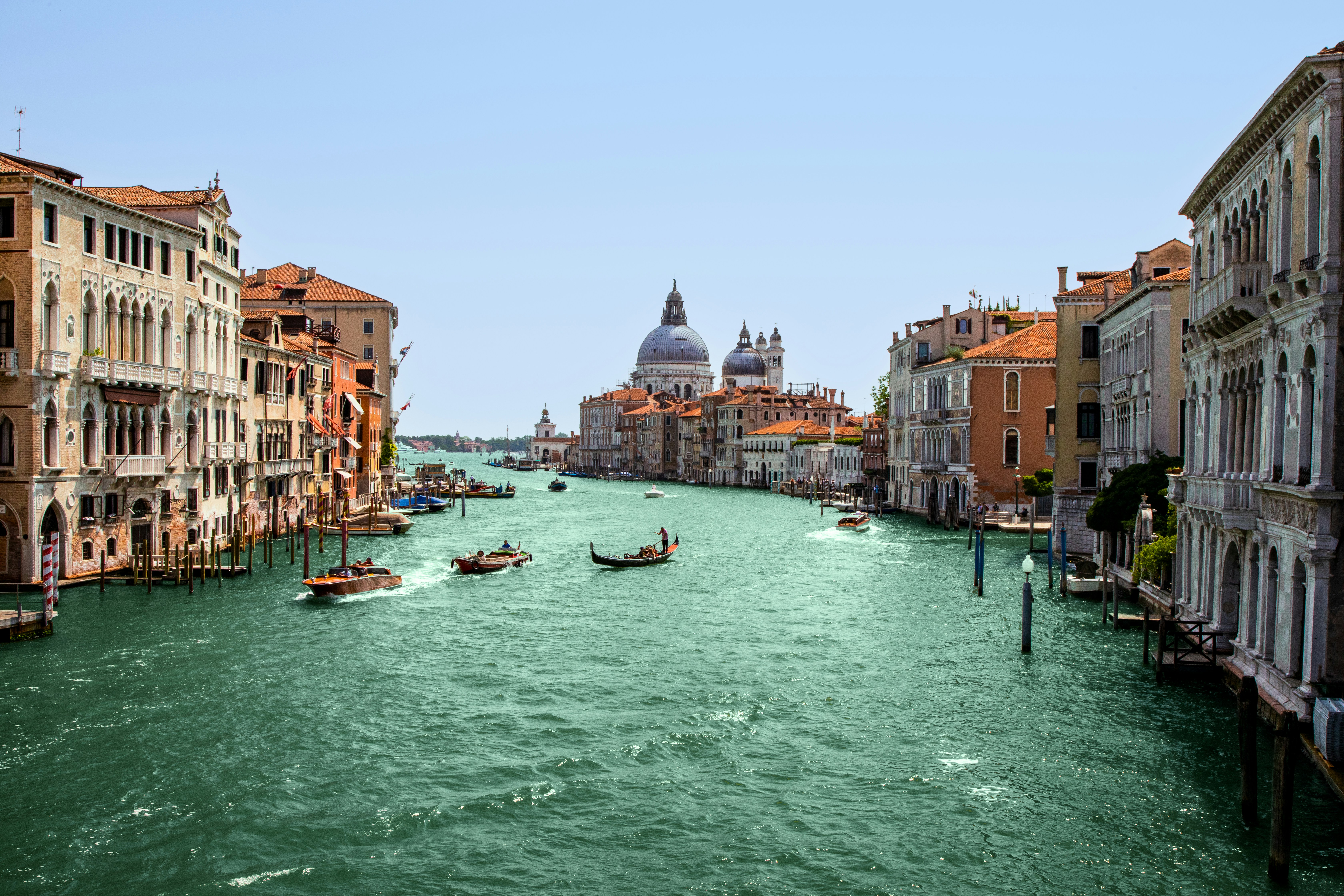A view of a canal with gondolas in the distance