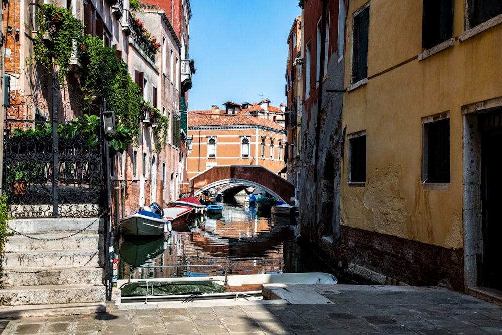 a narrow canal with a bridge in the background