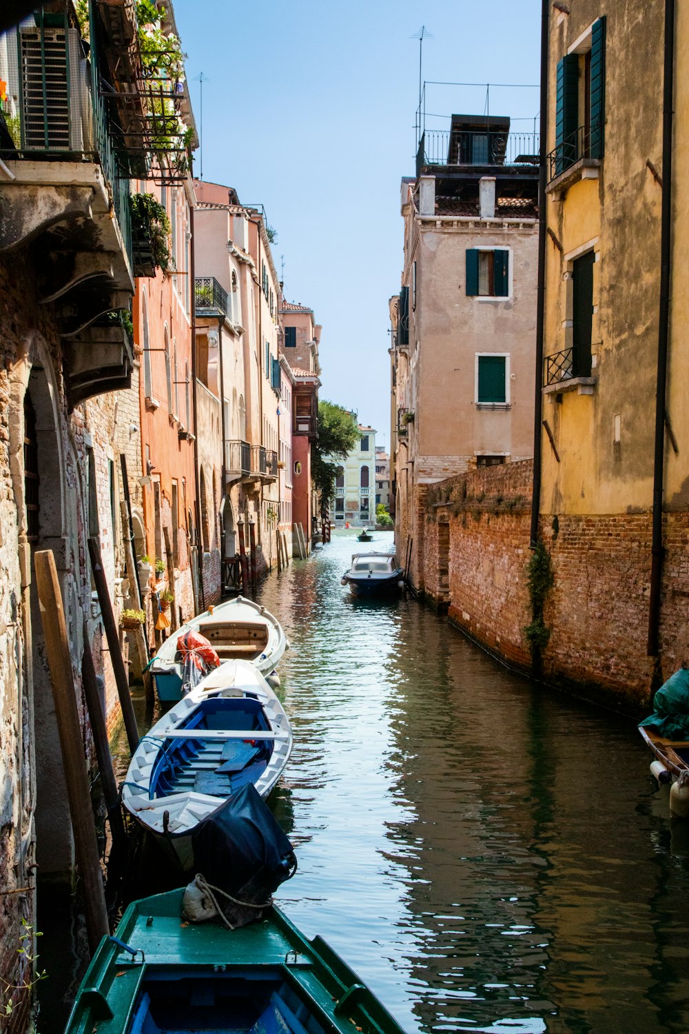 a narrow canal with several boats in it