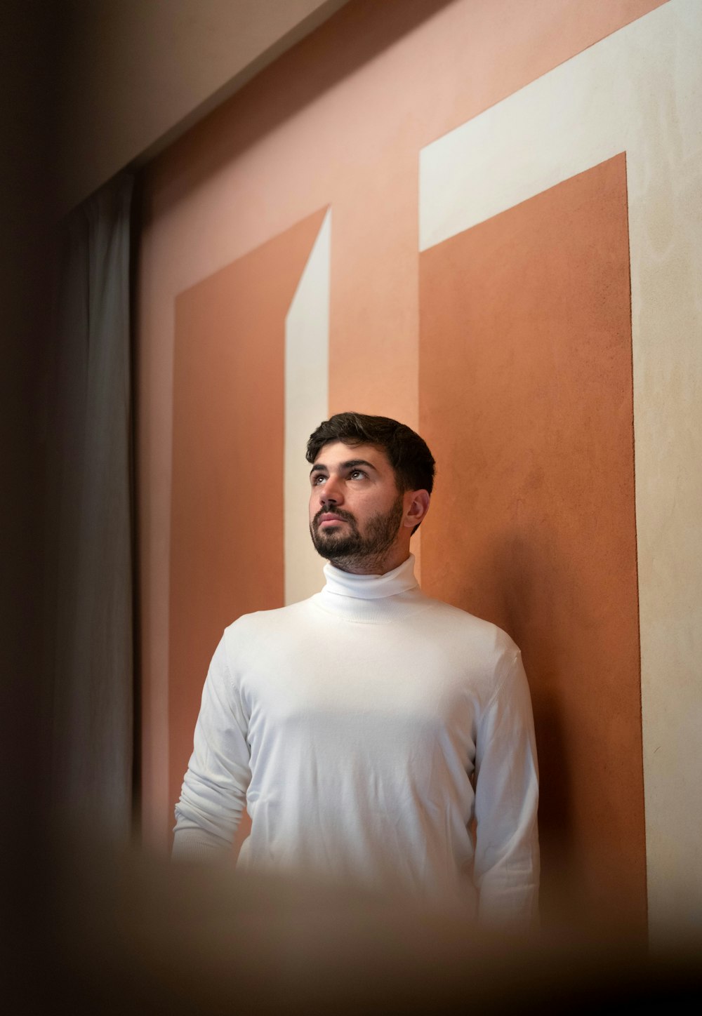 a man standing in front of a wall in a room