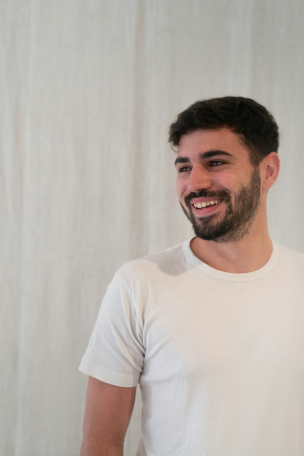 Un homme avec une barbe souriant à la caméra