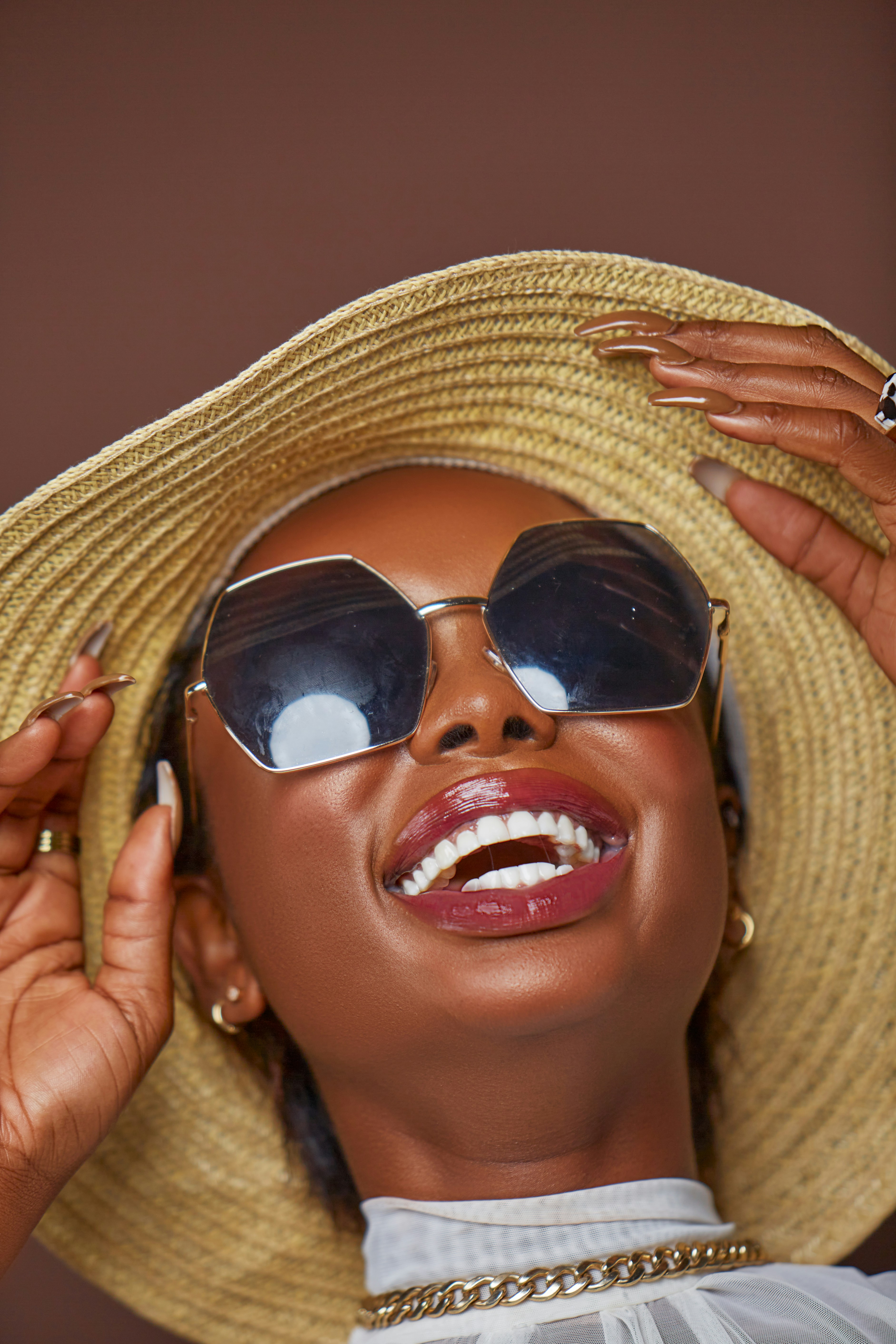 a woman wearing a straw hat and sunglasses