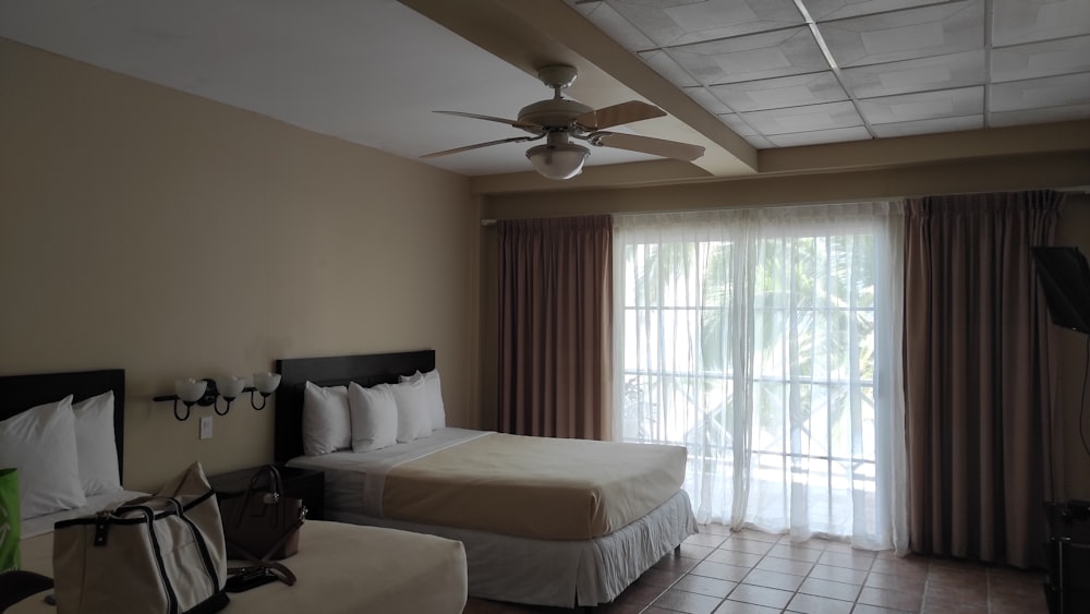 a hotel room with two beds and a ceiling fan