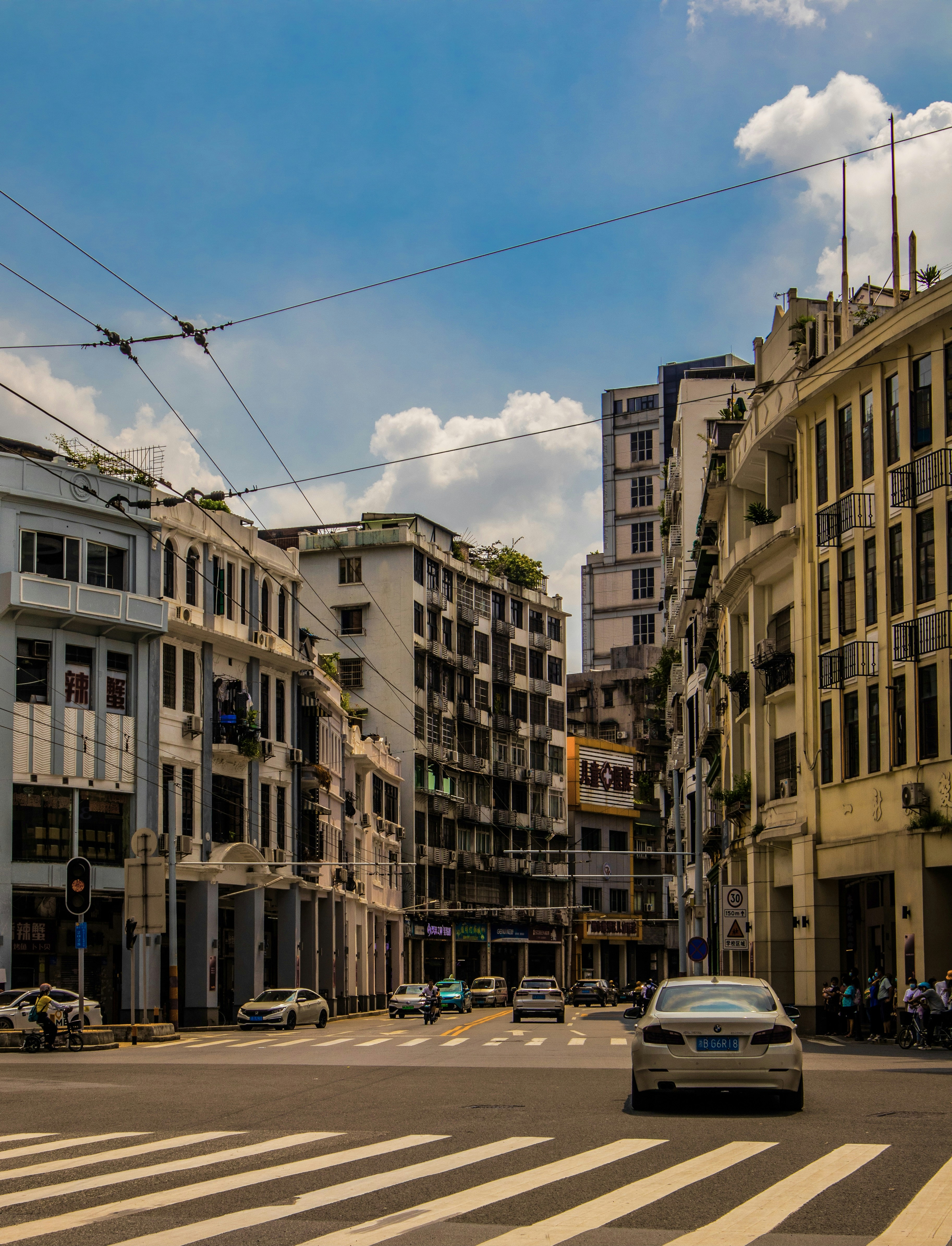 a car driving down a street next to tall buildings