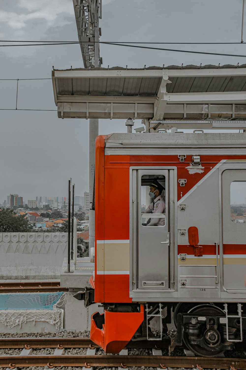 a red and white train traveling down train tracks