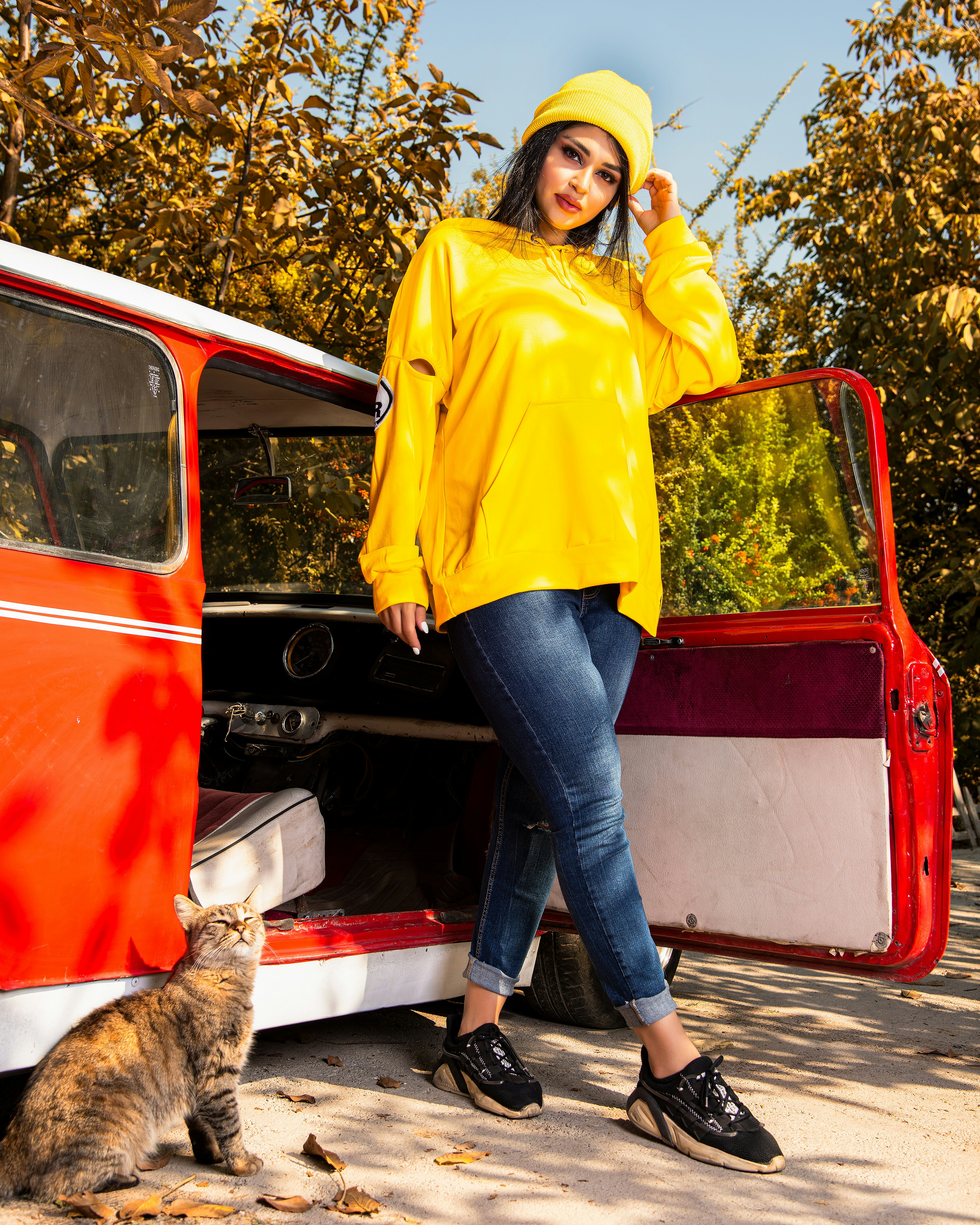 a woman in a yellow raincoat standing next to a van