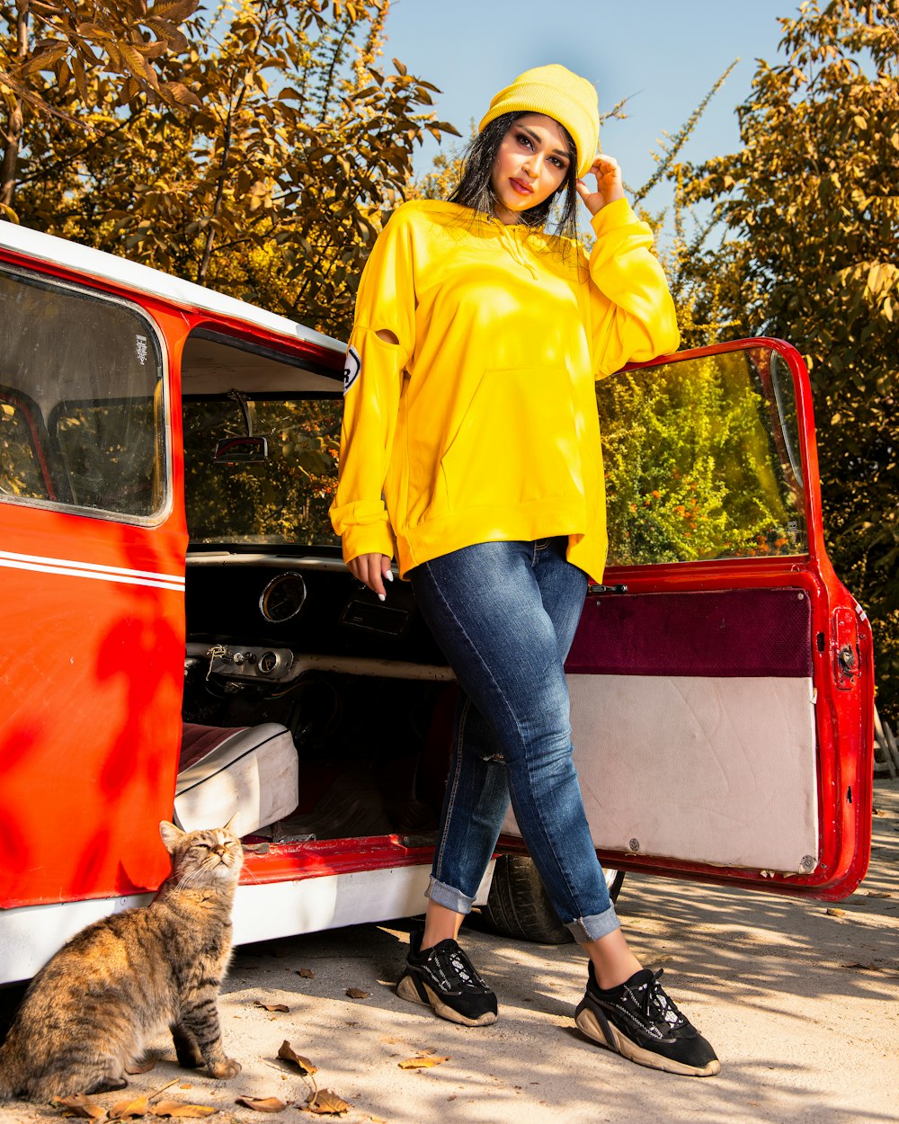 a woman in a yellow raincoat standing next to a van