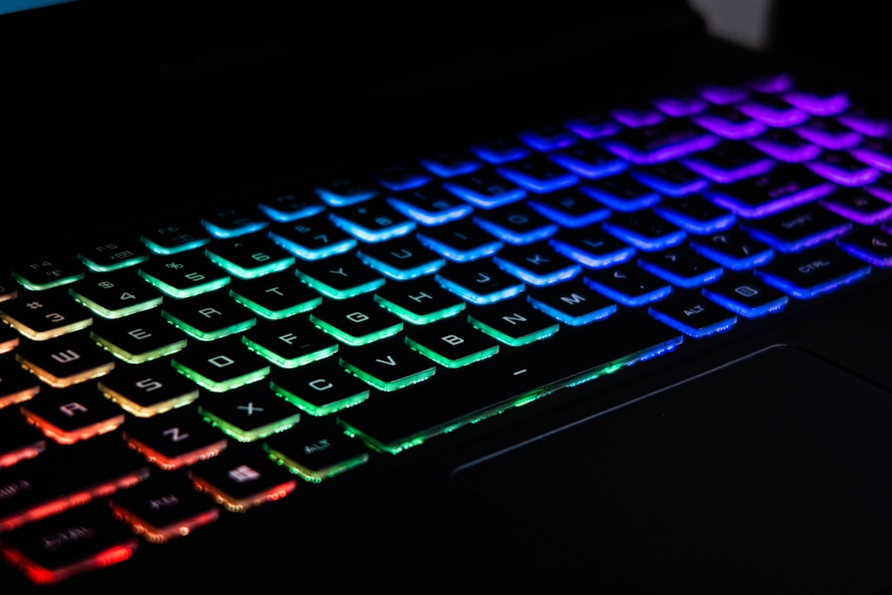 a close up of a keyboard with a rainbow light on it