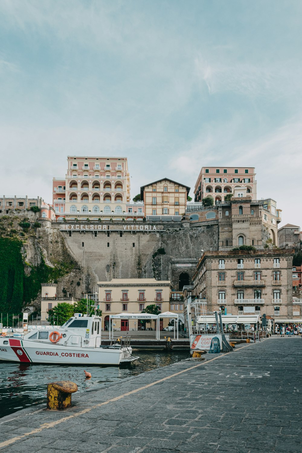 boats are docked in a harbor in front of a castle