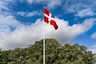 a red and white flag flying in the wind