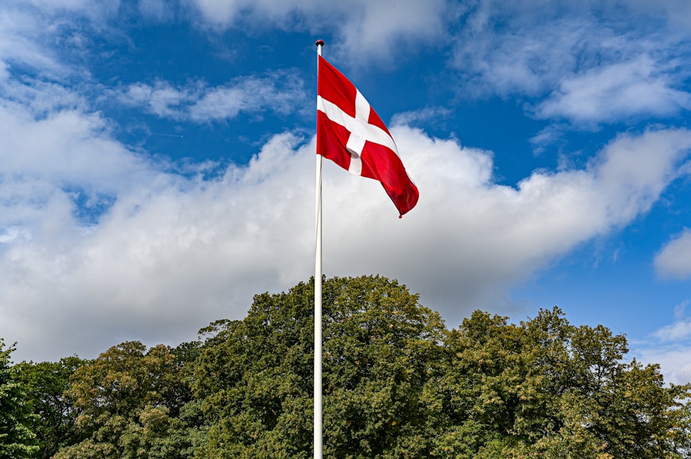 a red and white flag flying in the wind