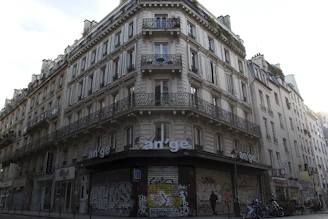 Technician inspecting building cracks with detailed notes in a Parisian neighborhood.