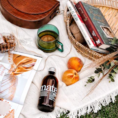 A woven decorative basket filled with colorful throws and magazines.