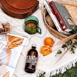 A woven rattan basket filled with cozy throws and magazines.