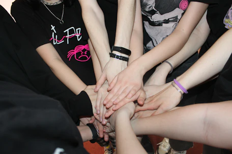 A group circle holding hands in a peaceful support meeting.