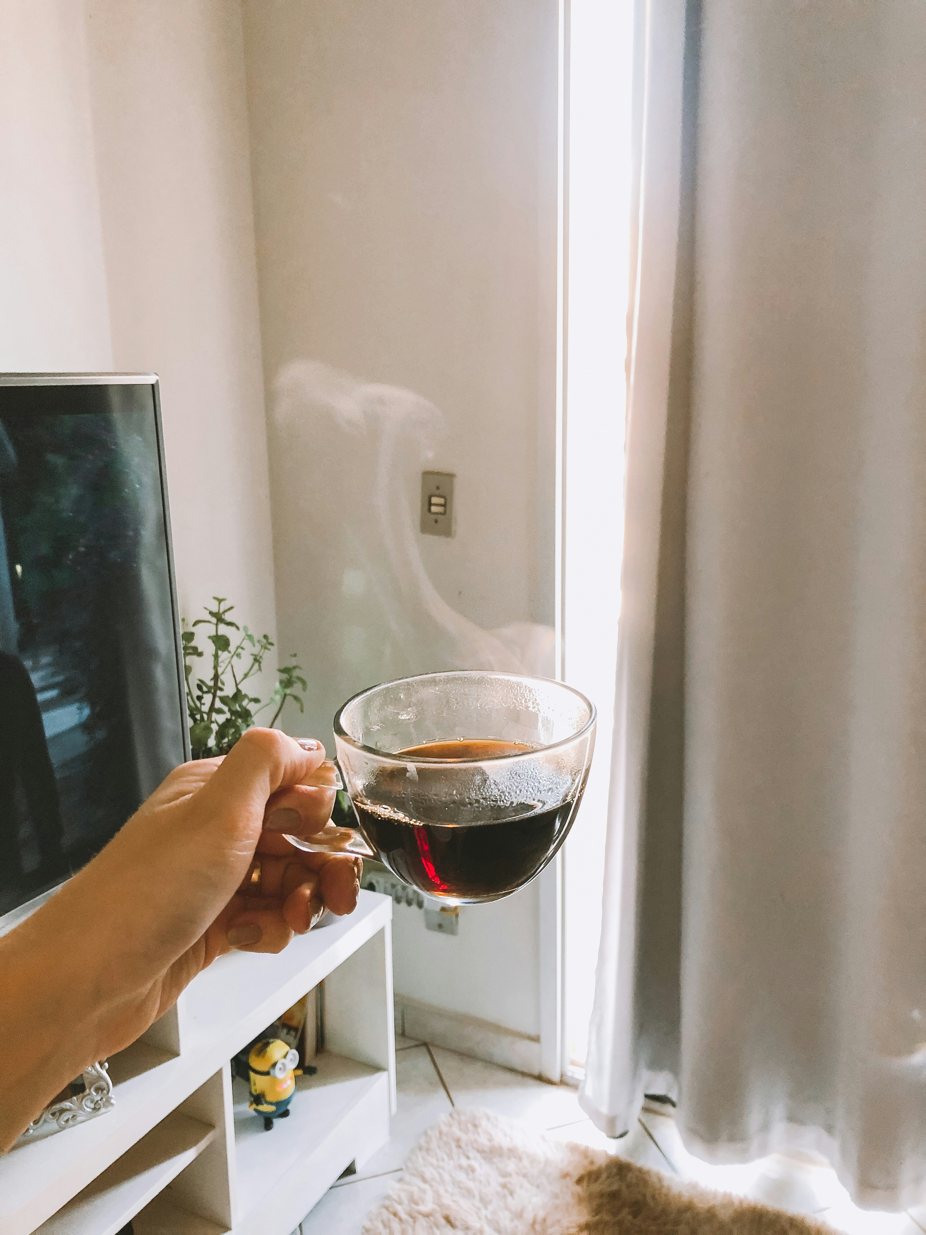 Smooth coffee in ceramic cup, warm amber tones, bright natural window light for dark text readability