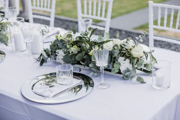 A beautifully set table for a wedding reception with sage green accents.