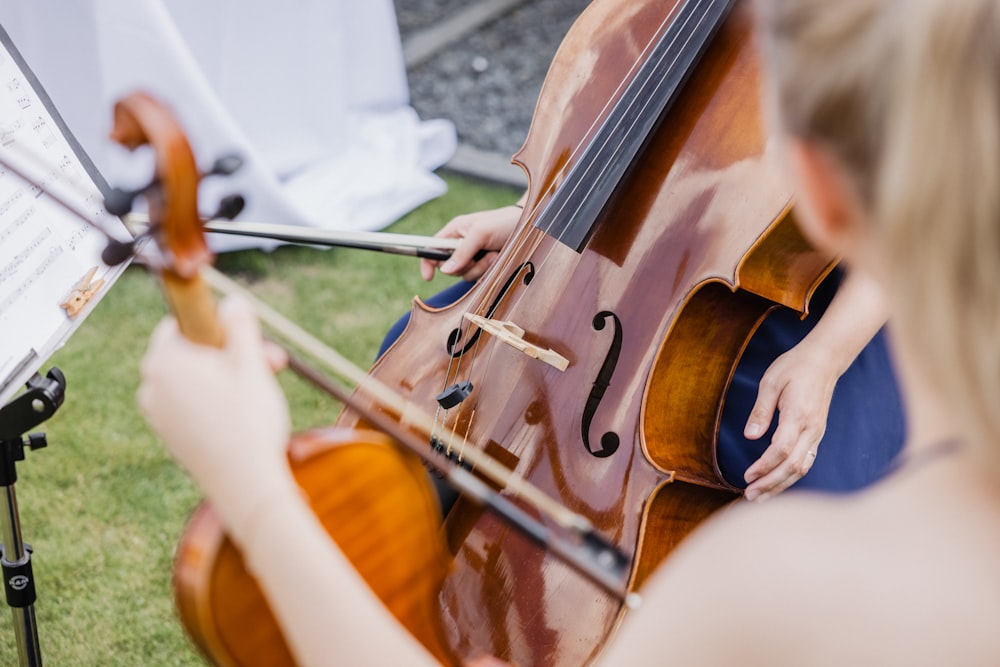 a woman playing a cello on the grass