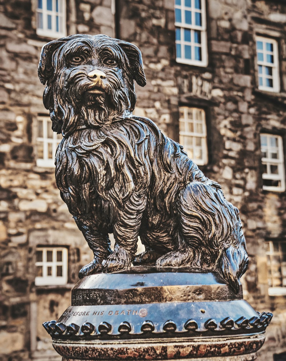 a statue of a dog sitting on top of a fire hydrant