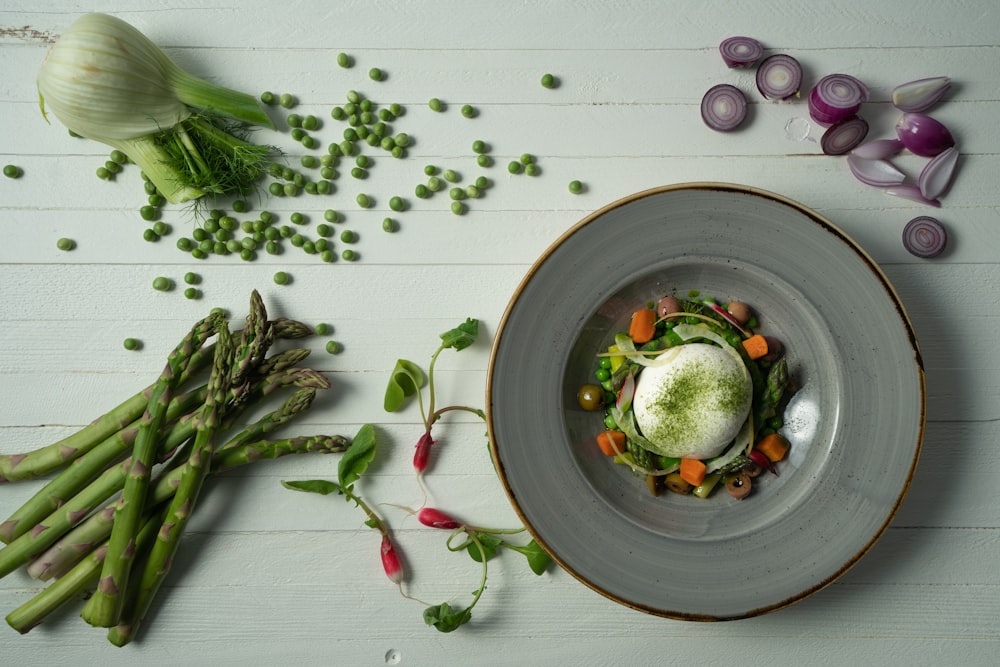 a plate of food with asparagus, carrots, and an egg