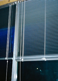 Professional installer adjusting a roller blind with precision in a commercial space