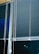 Horizontal blinds cover three large window panels. The blinds are partially closed, with several cords hanging down to adjust their position. The background outside the window is dark, suggesting it might be nighttime.