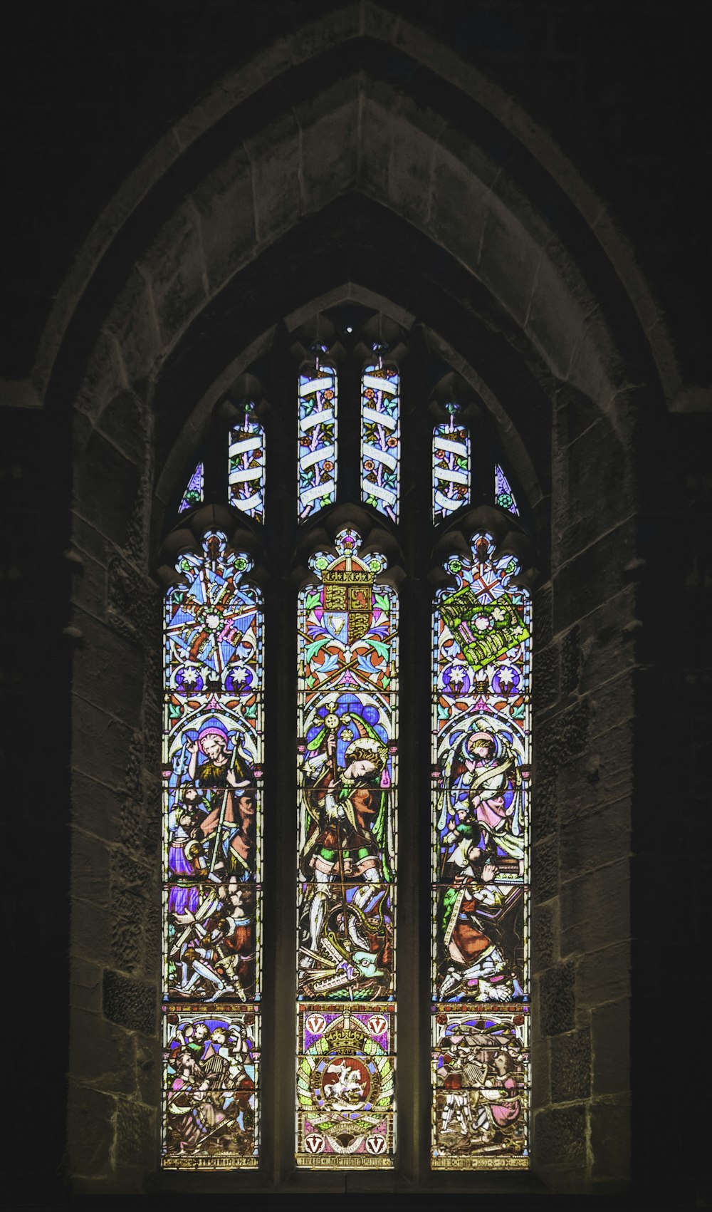 a large stained glass window in a stone building