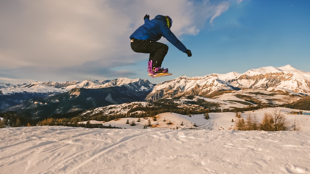 a man flying through the air while riding a snowboard