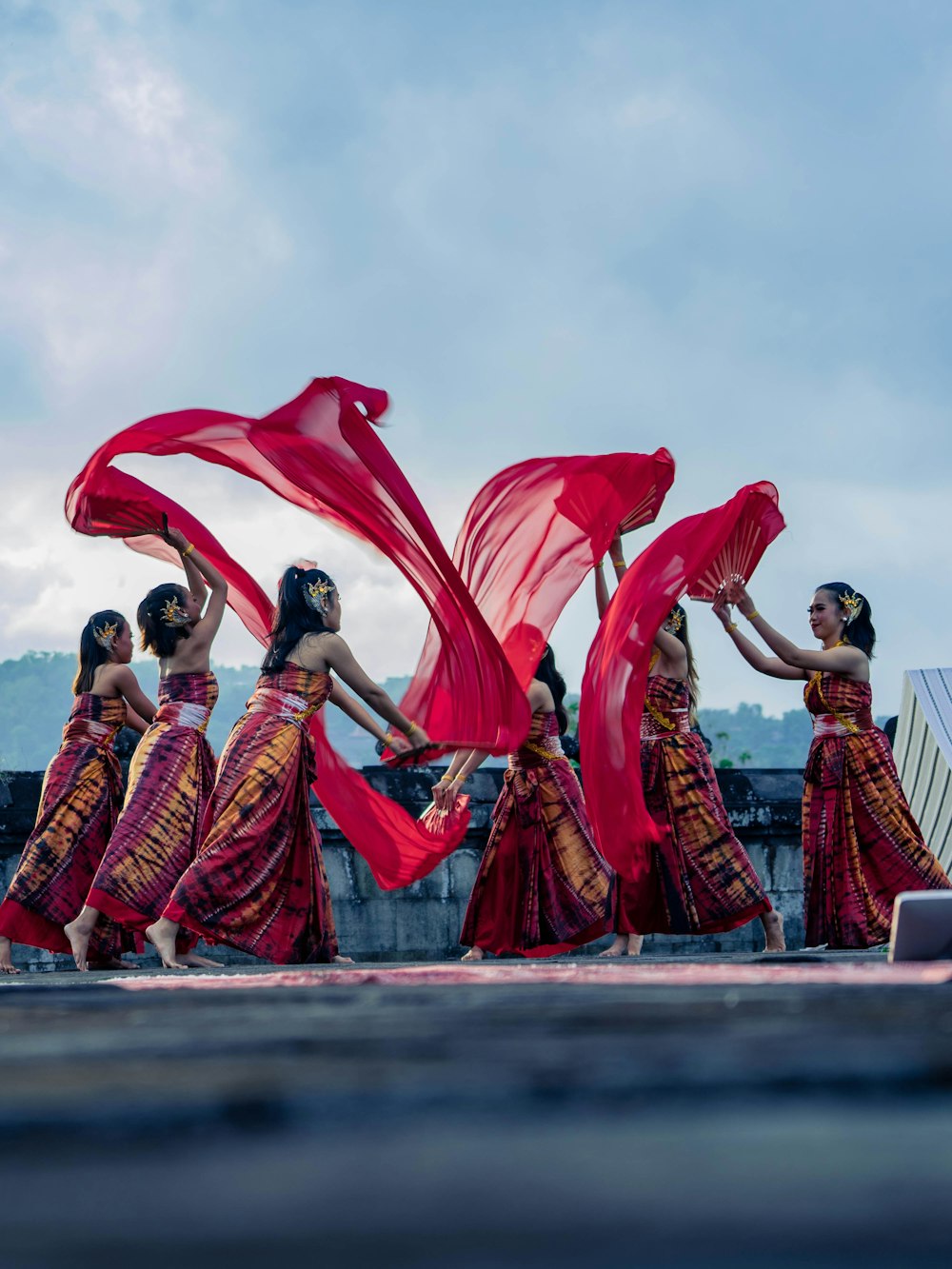 a group of women in red dresses dancing