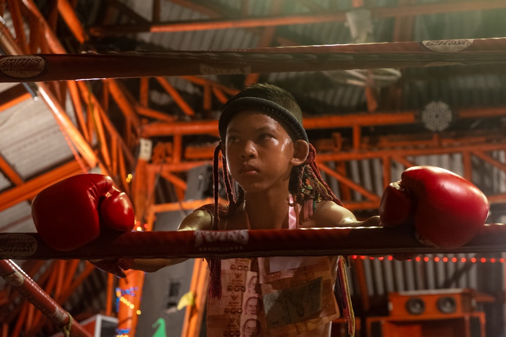 a woman in a boxing ring with red gloves