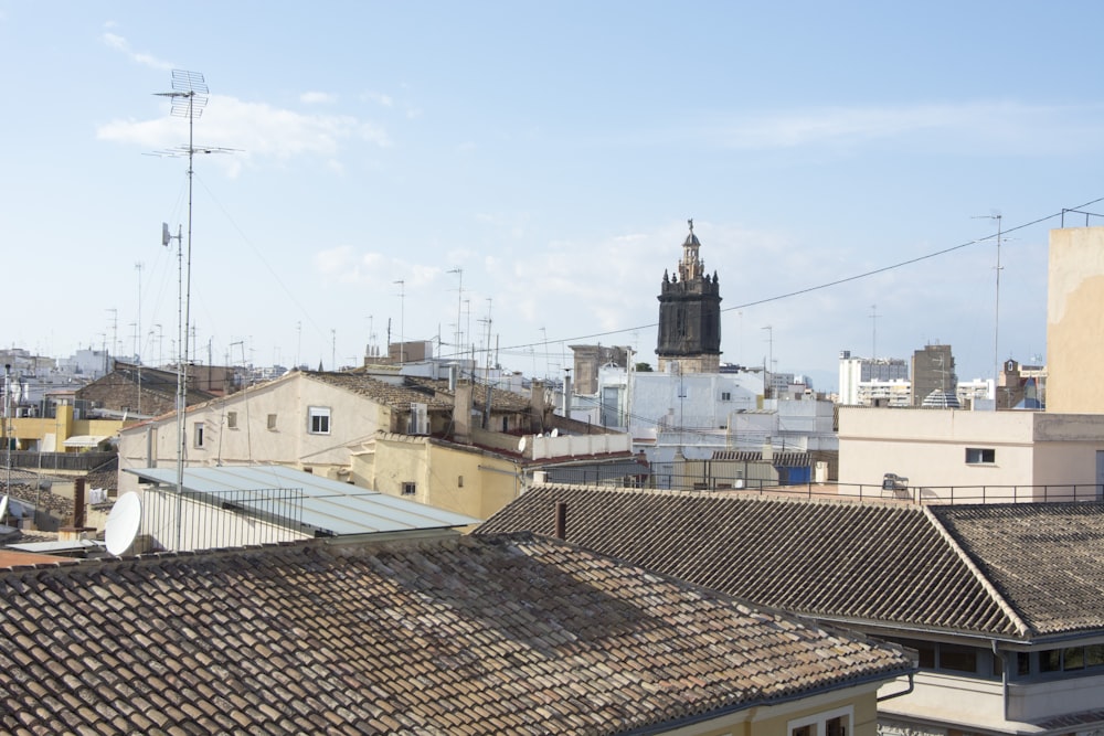 a view of a city with rooftops and a clock tower