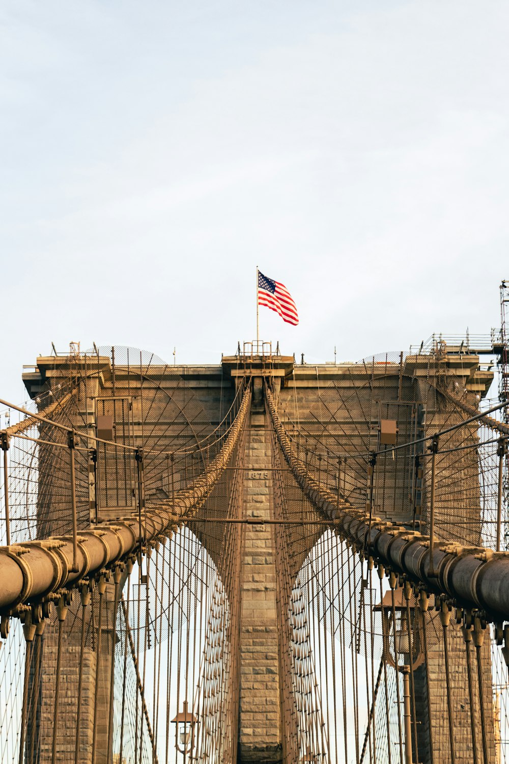 an american flag is on top of the top of a bridge